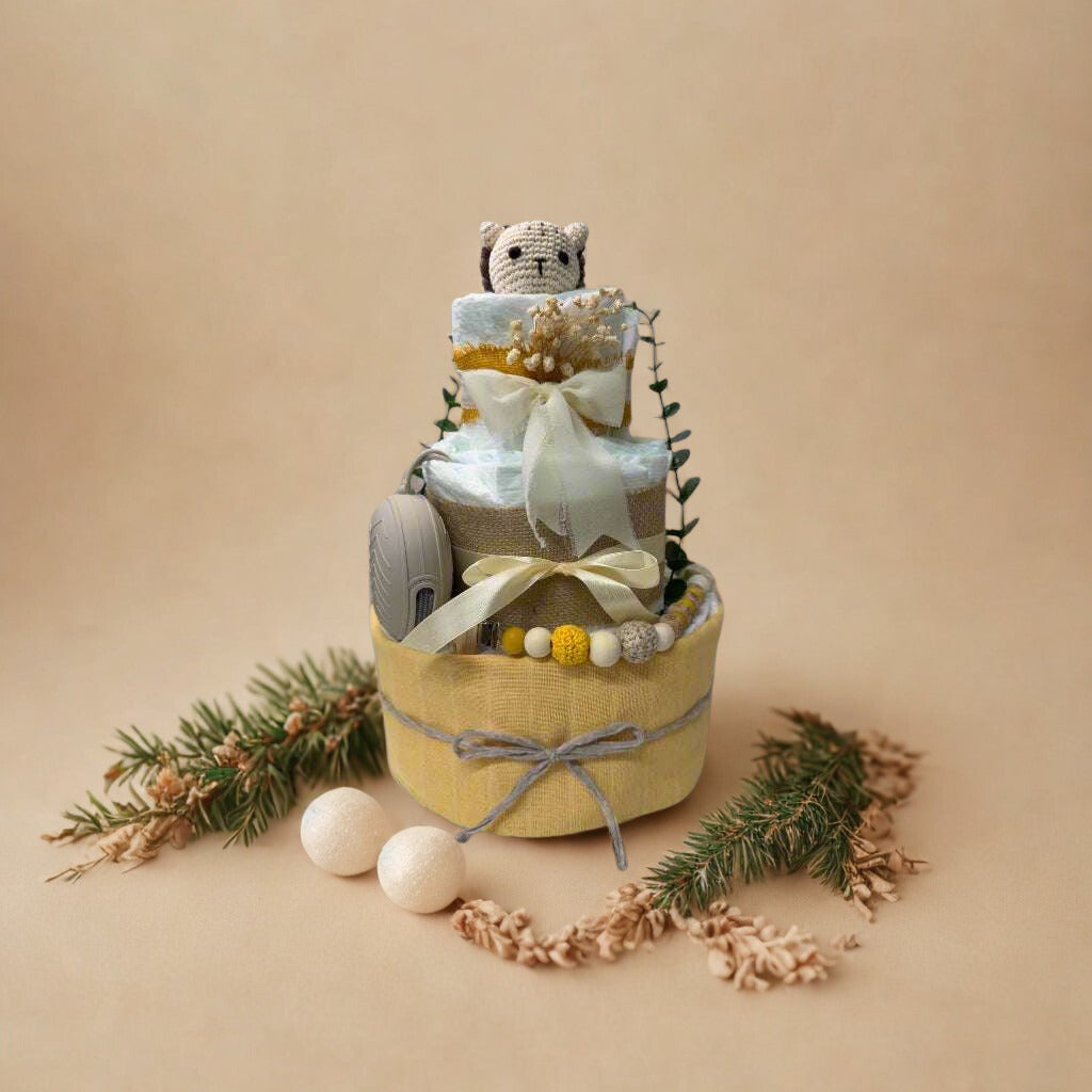 Sunny woodland diaper cake baby shower centerpiece featuring three tiers of rolled white diapers in soft yellow, cream, and natural tones. The base tier is wrapped in warm pastel yellow fabric and finished with a delicate gray twine bow for a subtle rustic touch.

The middle tier is accented with natural burlap ribbon and a soft ivory satin bow, complemented by a coordinating silicone and crochet beaded pacifier clip in shades of mustard, cream, and light gray. A matching neutral pacifier case is tucked nea